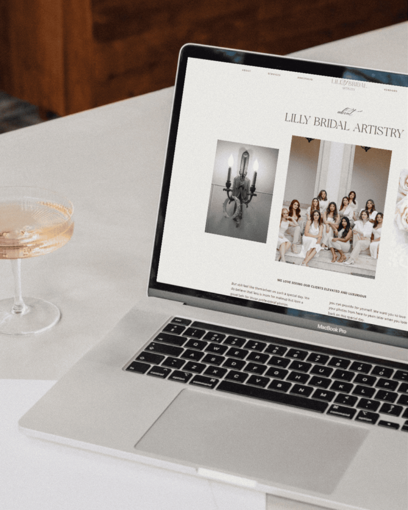 A laptop on a table showing a Web Design for a Small Business with a glass of wine 